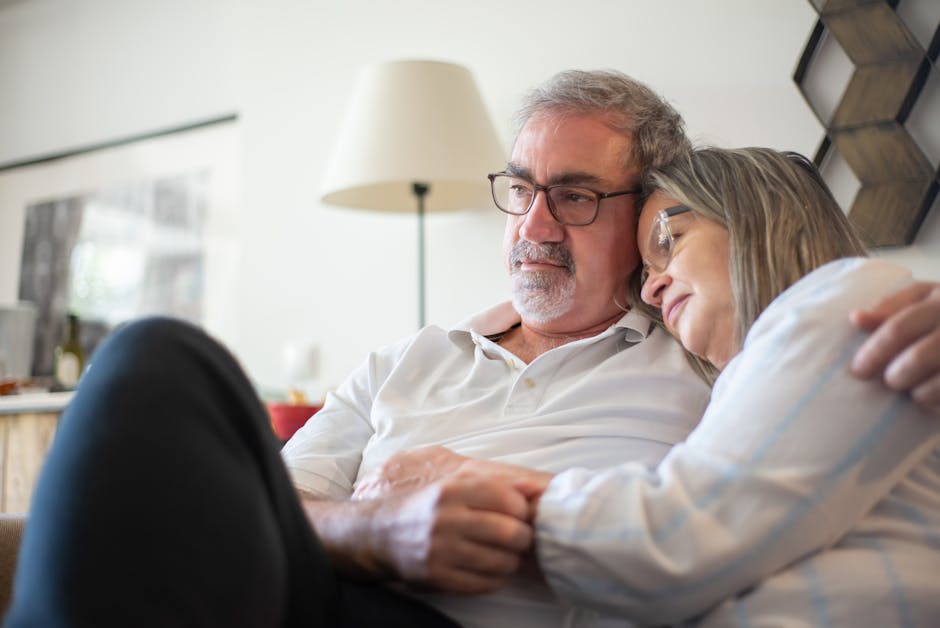 Senior couple embracing on a couch, enjoying a serene moment indoors in Portugal.