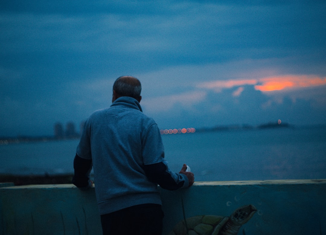 Man looking at the ocean at dusk