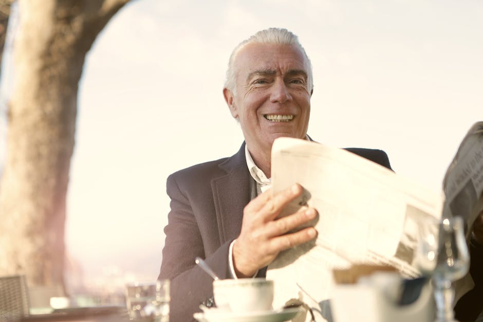 Elegant senior man enjoying a sunny day outdoors with coffee and newspaper.