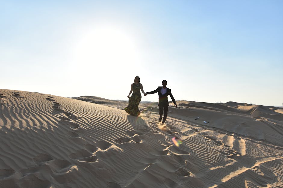 A couple holding hands and running through the dunes of the Dubai desert, showcasing romance and adventure.