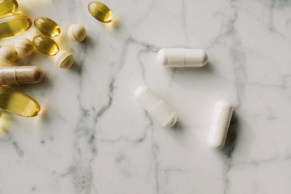 Close-up of various pills and capsules on a marble surface, ideal for healthcare themes.