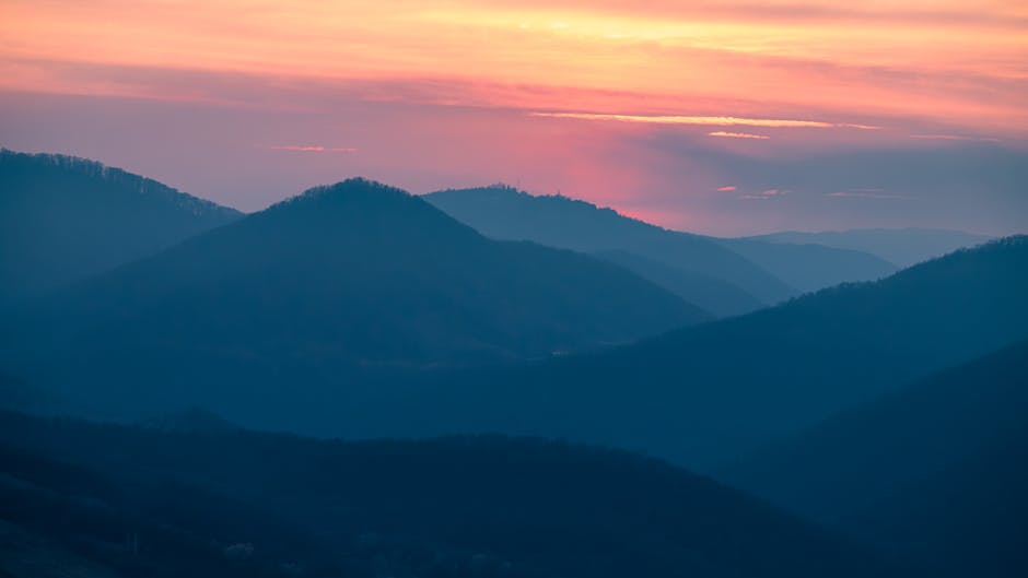 Beautiful silhouette of mountains under a vibrant sunset sky.