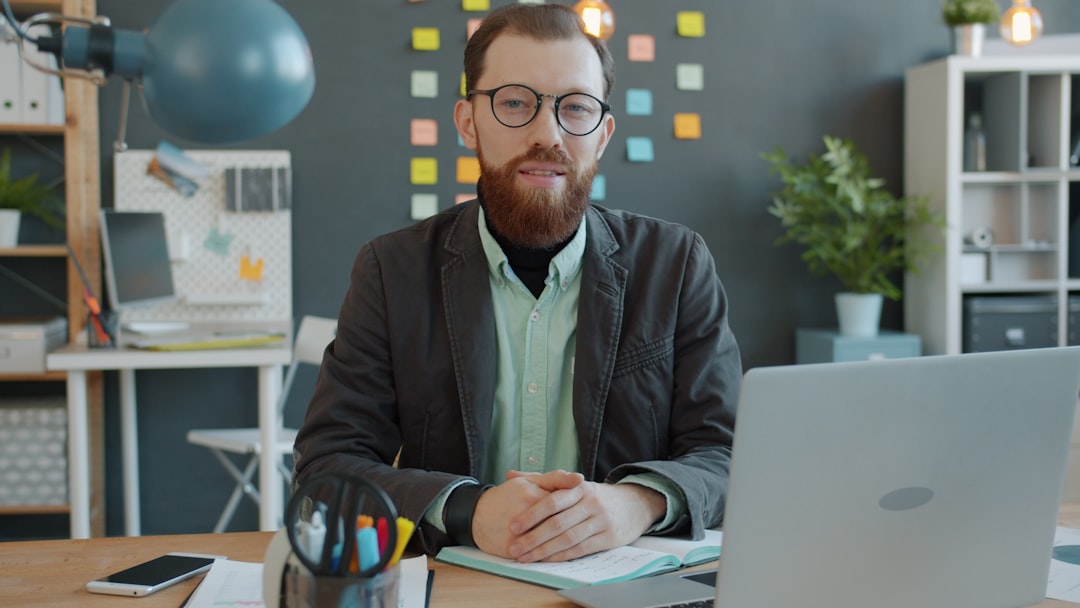 Man with beard and glasses at office desk
