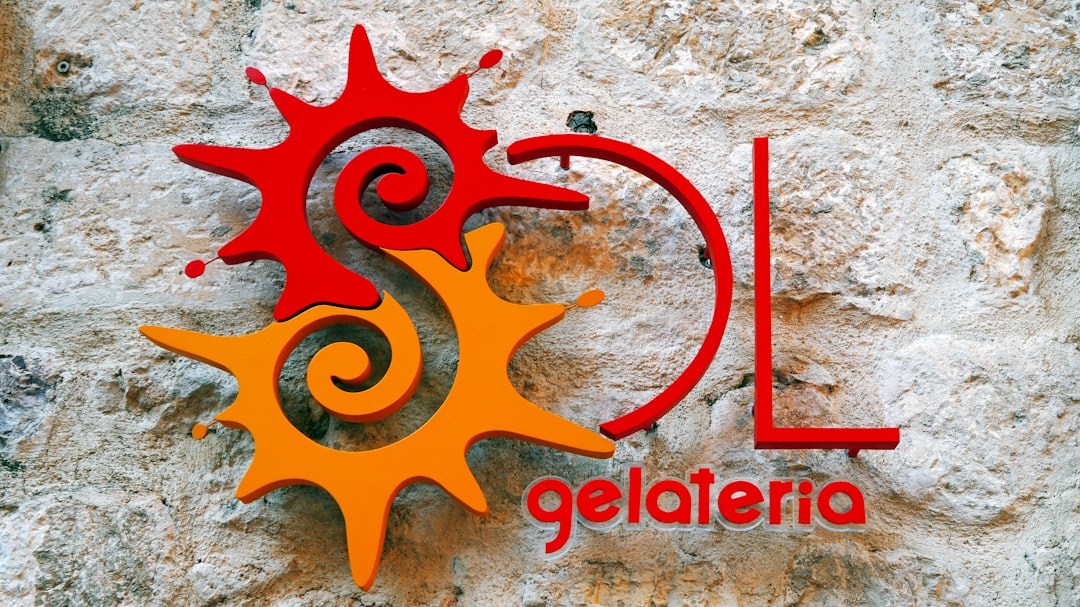 A red and orange logo on a stone wall