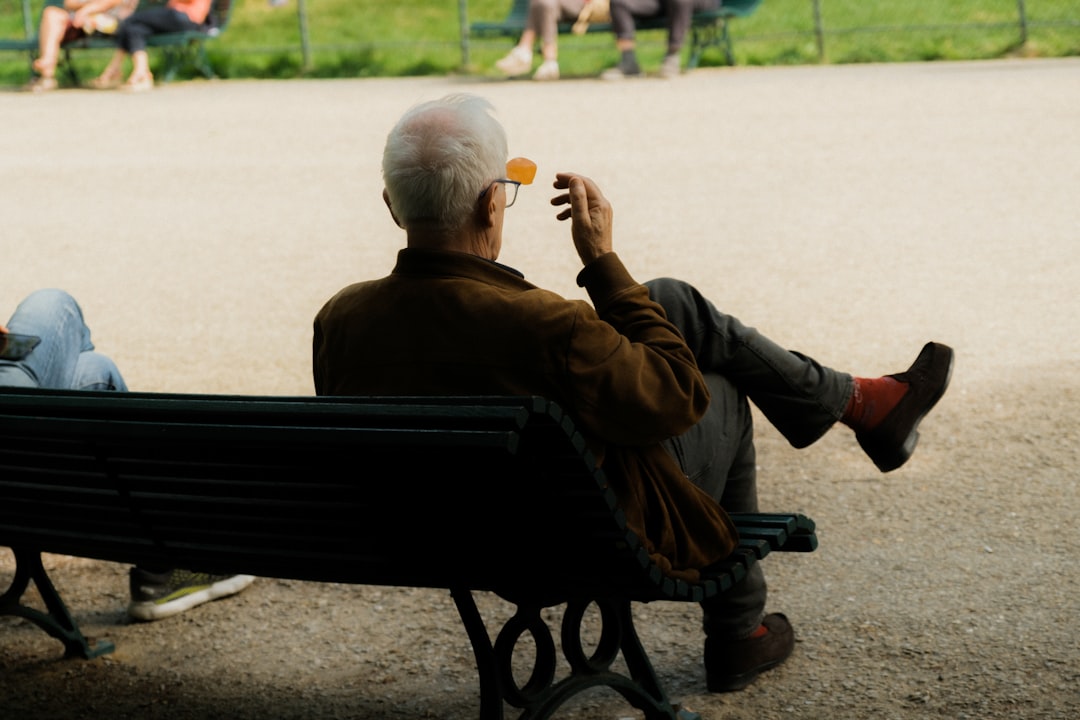 an older man sitting on a park bench