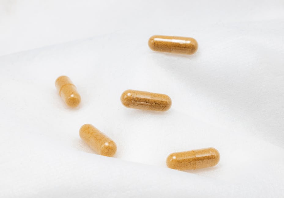 Close-up of brown capsules on a white surface, emphasizing health and supplements.